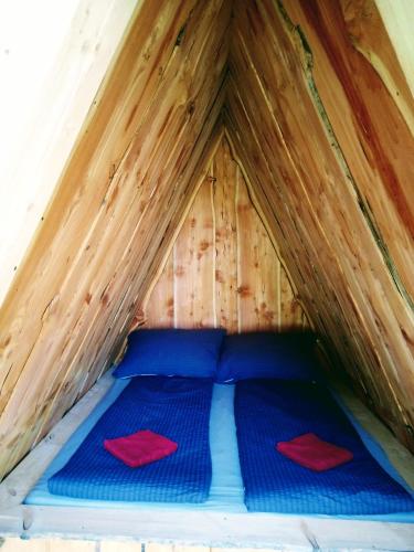 ein Bett in einem Zelt mit zwei roten Kissen darauf in der Unterkunft Camping Dreieck in Lenzing