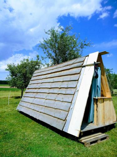 ein Schuppen mit einem Dach auf einem Feld in der Unterkunft Camping Dreieck in Lenzing