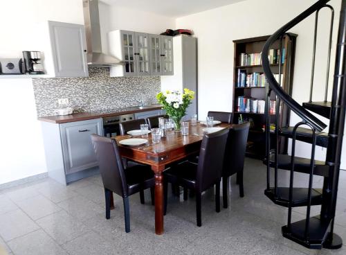 a kitchen with a wooden table and black chairs at Hochwertige Ferienwohnung direkt am Hafen mit Balkon in Ostseebad Karlshagen