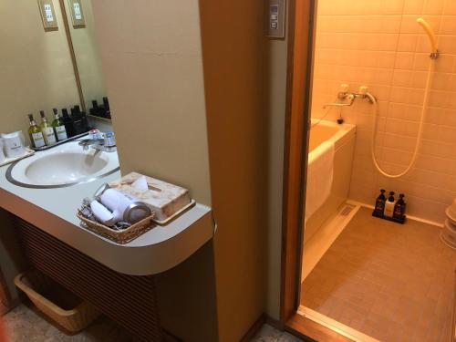 a bathroom with a sink and a bath tub at Ohashikan in Matsue