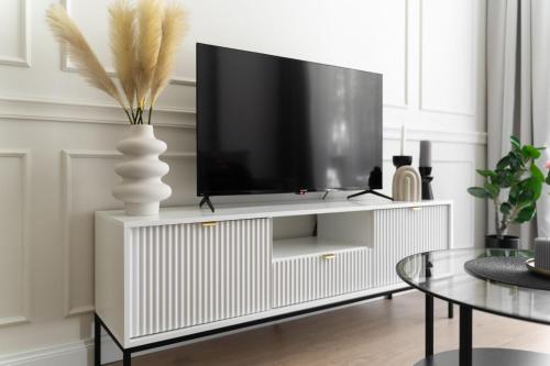 a living room with a tv on a white cabinet at HO!HOUSE SHELLTER ROGOWO in Rogowo