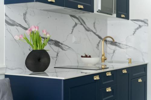 a kitchen with a counter with a vase with pink flowers at HO!HOUSE SHELLTER ROGOWO in Rogowo