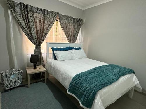 Un dormitorio con una cama grande y una ventana en The Urban Hub in Block 5, en Gaborone