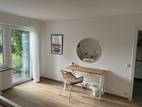 a white room with a desk and a mirror at Moderne Ferienwohnung in der Festspielstadt Bayreuth - zentral und dennoch ruhig gelegen in Bayreuth