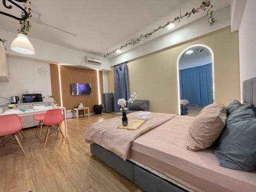 1 Schlafzimmer mit einem großen Bett und einem Esszimmer in der Unterkunft CozySuite@ SUN GEO & Linked to Sunway Medical, Sunway Uni & Sunway Pyramid in Petaling Jaya