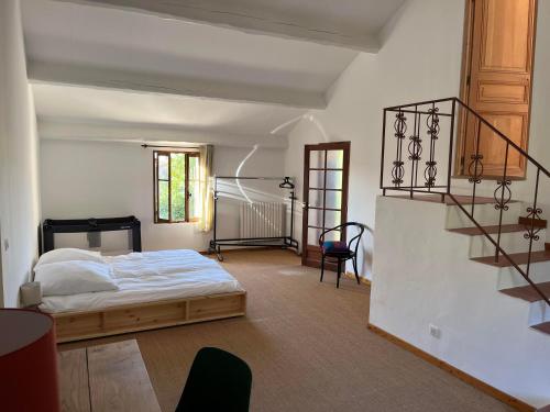 een slaapkamer met een bed en een trap erin bij Maison Seillans les Fontaines in Seillans