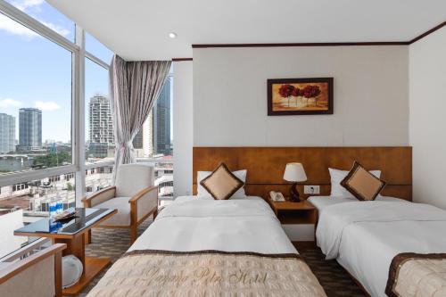 a hotel room with two beds and a large window at Danang Petro Hotel in Da Nang