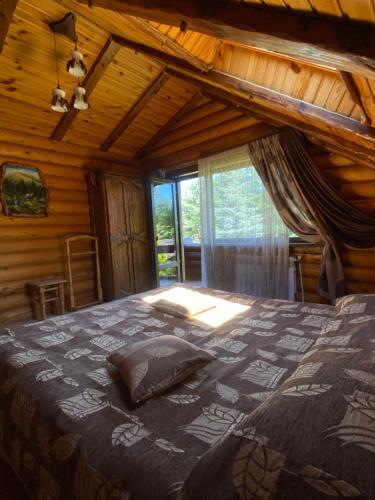 a bedroom with a large bed in a cabin at Sofiya in Mykulychyn