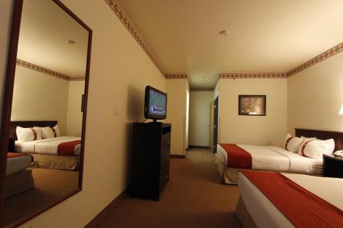 a hotel room with two beds and a mirror at Ramada by Wyndham Williams/Grand Canyon Area in Williams