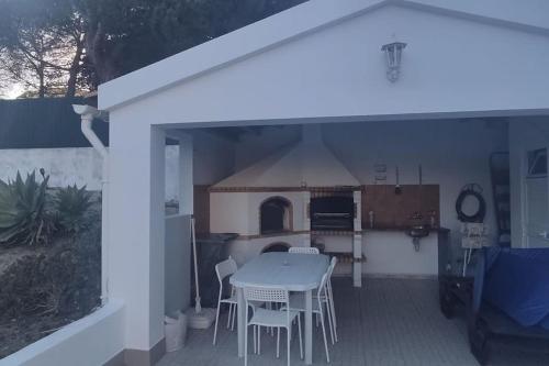 a patio with a table and chairs and a kitchen at Calma na Lagoa de Albufeira, Castelo Sesimbra. in Sesimbra