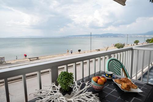 un tavolo con cibo su un balcone con vista sulla spiaggia di Ammos Lux Apartments a Agia Triada