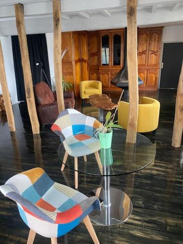 a living room with a glass table and chairs at Le Relais in Vandenesse-en-Auxois