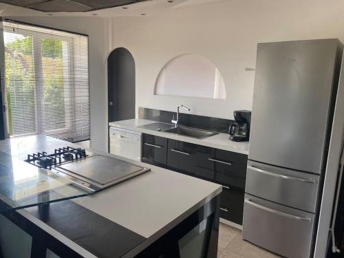 a kitchen with a refrigerator and a counter top at Le Relais in Vandenesse-en-Auxois