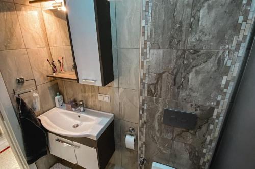a bathroom with a sink and a shower with a mirror at "Kale Street" Alanya in Alanya