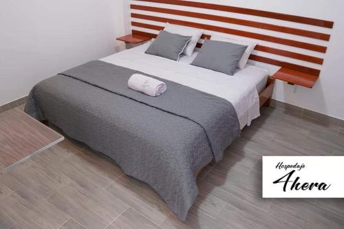 a bedroom with a large bed with a wooden headboard at Hospedaje 4Hera in Satipo