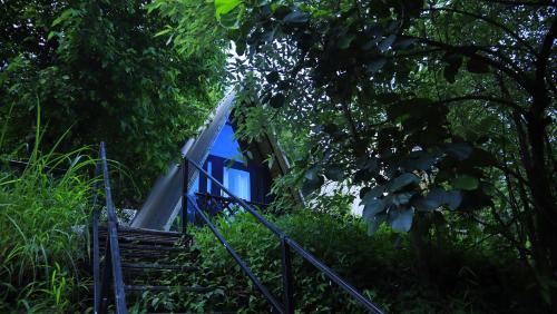a blue train is going through the trees at Beyond Stay Arnahyam Resort Sattal in Bhīm Tāl