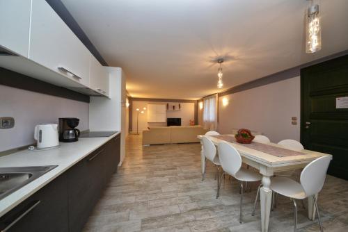eine Küche und ein Esszimmer mit einem Tisch und Stühlen in der Unterkunft Appartamento Enrichetta in Manerba del Garda