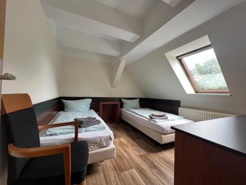a small room with two beds and a window at Apart Pension Plaue in Brandenburg an der Havel