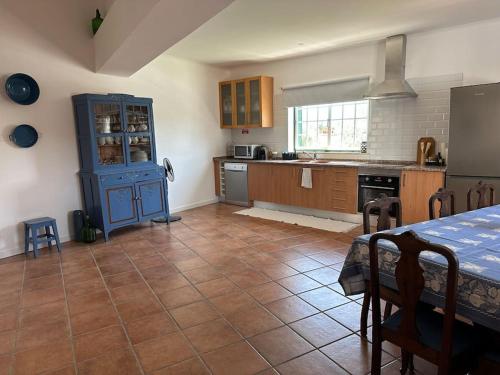 a kitchen with a table and a blue cabinet at Casa Bé-Bia in Carvalhal