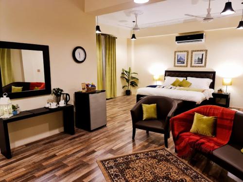 1 dormitorio con cama, silla y espejo en The Mandarin Inn, en Gilgit