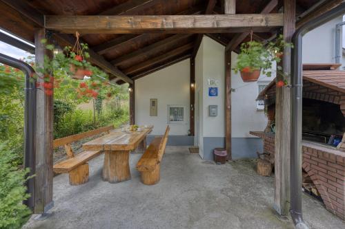 a patio with a wooden table and benches at Plitvice Lakes House By The Creek - Happy Rentals in Korenica