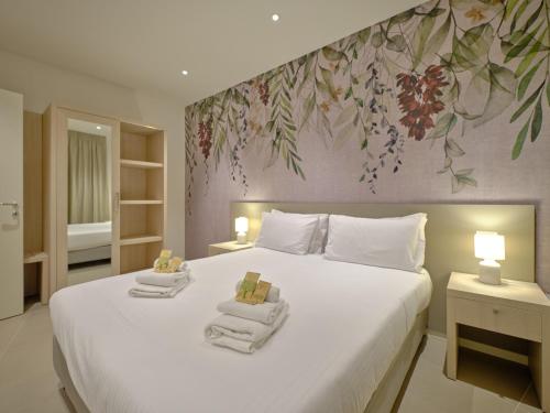a bedroom with a large white bed with towels on it at ApartmentsArena - Residenza Dei Doganieri - Verona in Verona