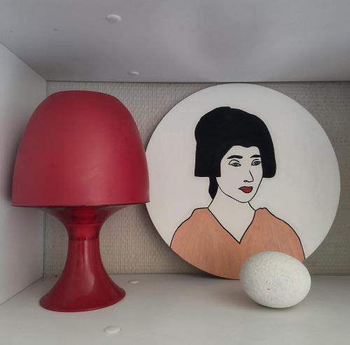 a red lamp and a picture of a woman at Studio moderne, propre et calme in Melun
