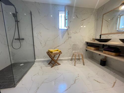 a bathroom with a shower and a sink and a stool at Le Val d'escure in Saint-Raphaël