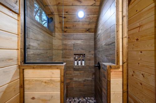 um chuveiro numa cabina de madeira com uma porta em Bright Modern Luxury - Broken Bow Dream Retreat em Broken Bow