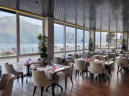 a dining room with tables and chairs and windows at Hotel Bazzoni in Tremezzo
