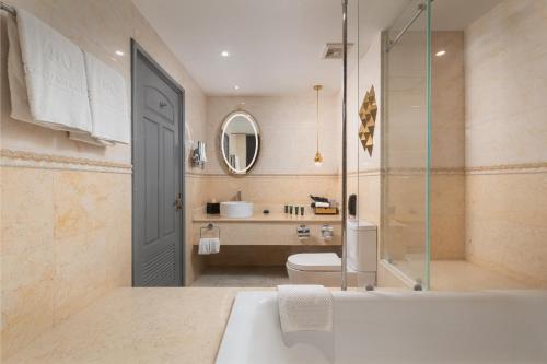 a bathroom with a tub and a toilet and a sink at Royal Tian Li Hotel in Yangon