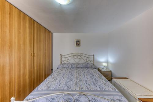 1 dormitorio con 1 cama y armario de madera en Casa di Marika, en Marina di Leuca