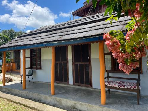 uma pequena casa com um banco à frente em Rupa View Guest house em Pokhara