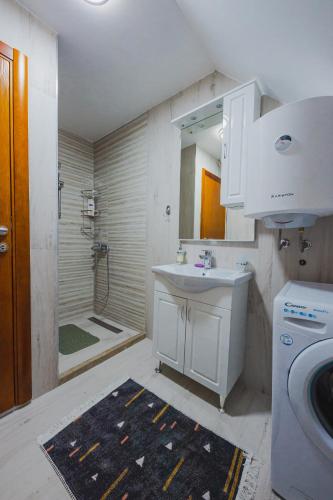 a white bathroom with a sink and a shower at Vila Rea in Žabljak