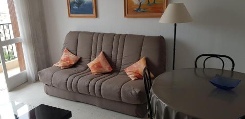 - un salon avec un canapé, des oreillers et une table dans l'établissement Proche de tout prés du centre de golfe juan coin calme, à Vallauris