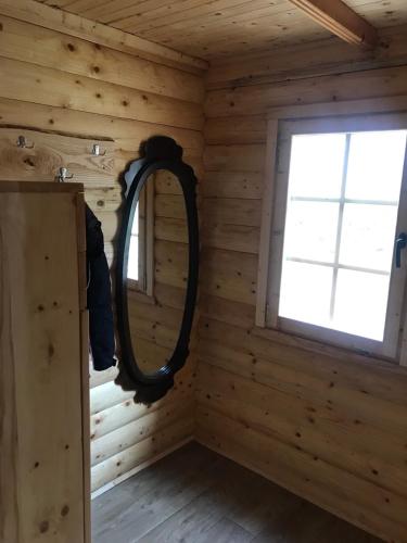 a mirror in the corner of a log cabin with a window at Holiday Home JASEN in Kolašin