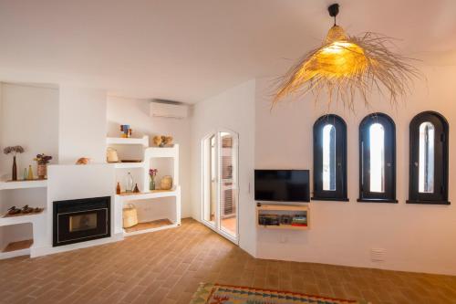 un soggiorno con camino e TV di Cozy Beach Apartment W/ Sea View, Free Parking & AC a Carvoeiro