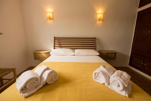 una camera da letto con un letto con asciugamani sopra di Cozy Beach Apartment W/ Sea View, Free Parking & AC a Carvoeiro