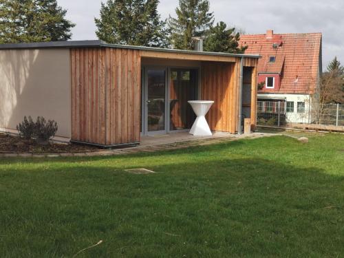 a house with a large pivot door in a yard at Baumhaus und Tinyhaus in Mühlhausen