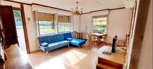 uma sala de estar com um sofá azul e uma mesa em Casa de verano La Gaviota en Asturias em Villaviciosa