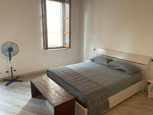 um quarto com uma cama, uma janela e uma ventoinha em Casa in piazzetta em Rivergaro