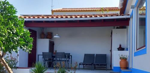 a patio with chairs and a table on a house at Casa das Rosas in Crato