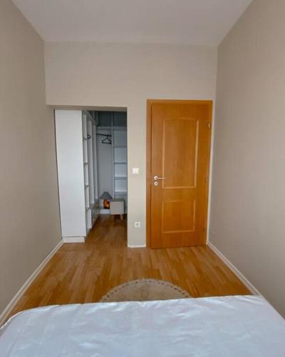a bedroom with a bed and a wooden door at Siera's Penthouse in Pristina