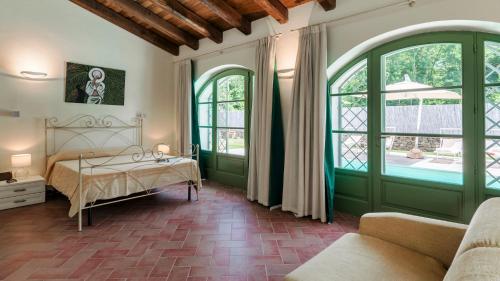a bedroom with a bed and two large windows at Villa Elsa 6, Emma Villas in Filetto
