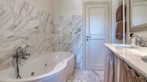 a white bathroom with a tub and a sink at Villa Elsa 6, Emma Villas in Filetto
