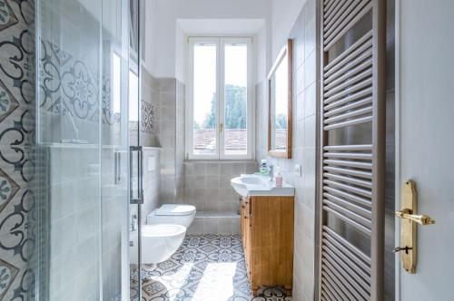 Lucca Historic & Cozy Central Apartment! في لوكّا: حمام مع مرحاض ومغسلة ونافذة