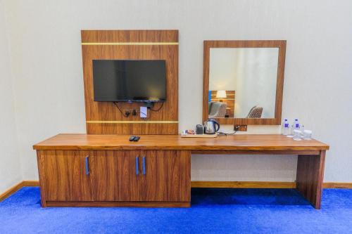 a wooden desk with a television and a mirror at The Epitome in Kurunegala