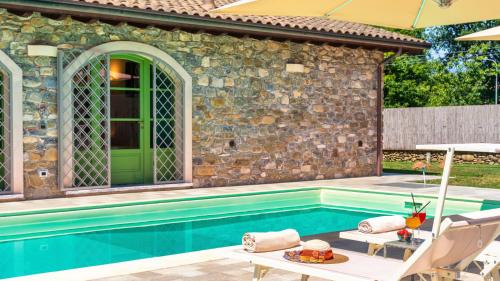 a swimming pool in front of a house at Villa Elsa 6, Emma Villas in Filetto
