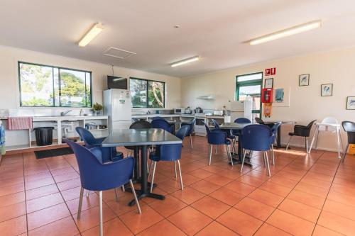 a cafeteria with tables and chairs and a kitchen at BIG4 Tassie Getaway Park Stanley in Stanley