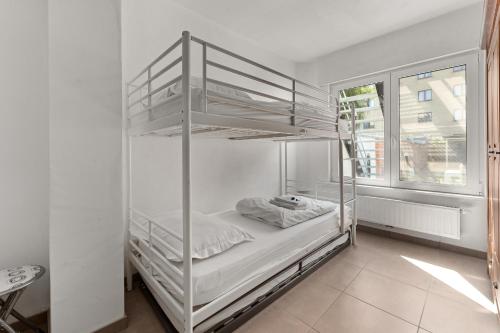 ブランケンベルヘにあるRuime woning 10p met zonnige tuin & nabij strandのベッドルーム1室(二段ベッド2台、窓付)が備わります。